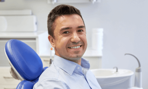 a smiling male patient on dental chair a smiling male patient on dental chair